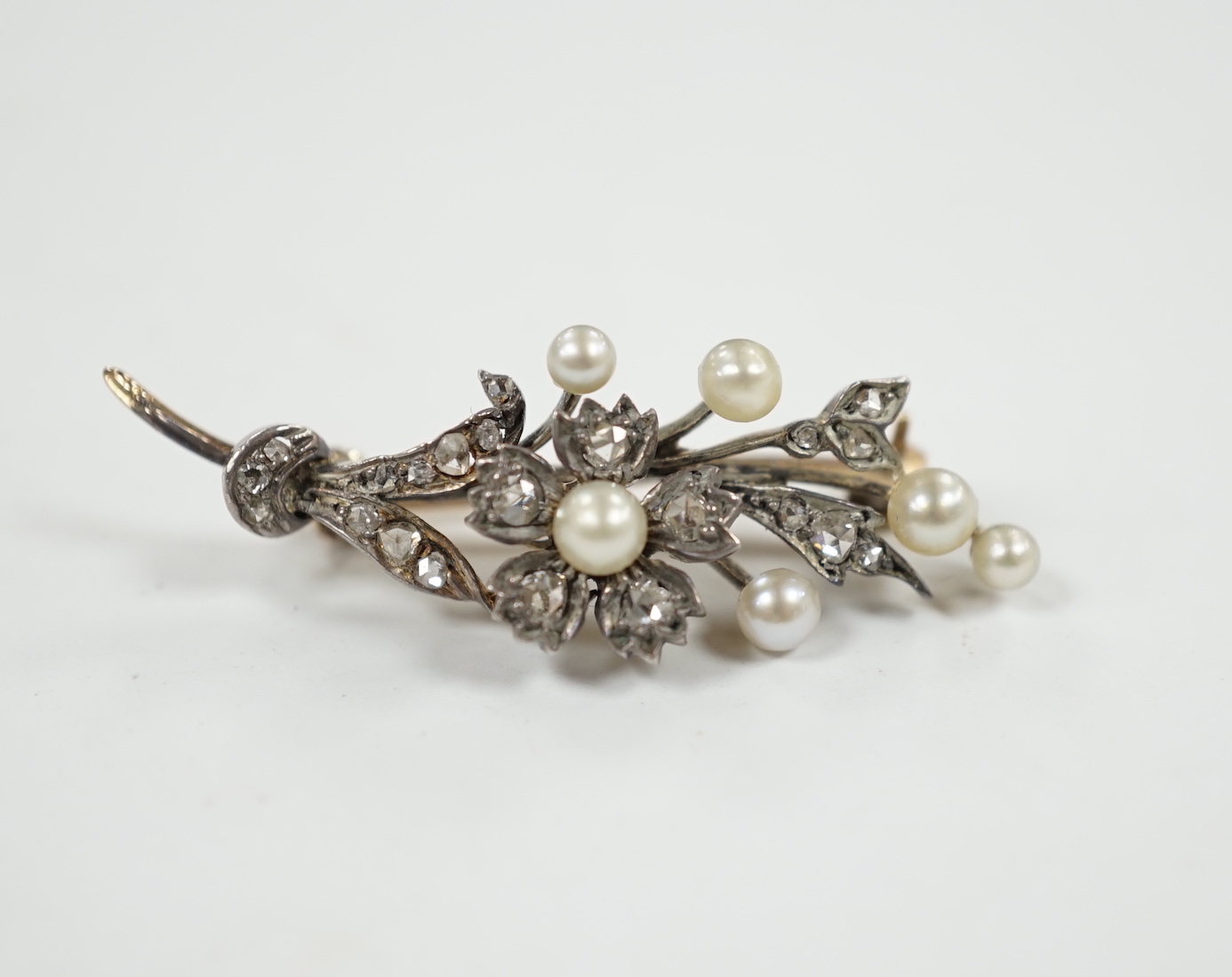 A cased Victorian yellow metal, seed pearl and rose cut diamond set foliate spray brooch, 39mm, gross weight 4.4 grams.